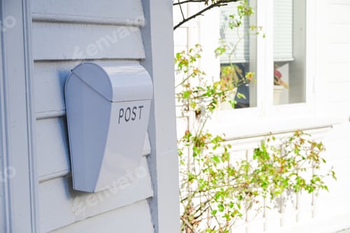 Preview: A traditional white metal mailbox with the word POST on a wooden wall of a house in Norway
