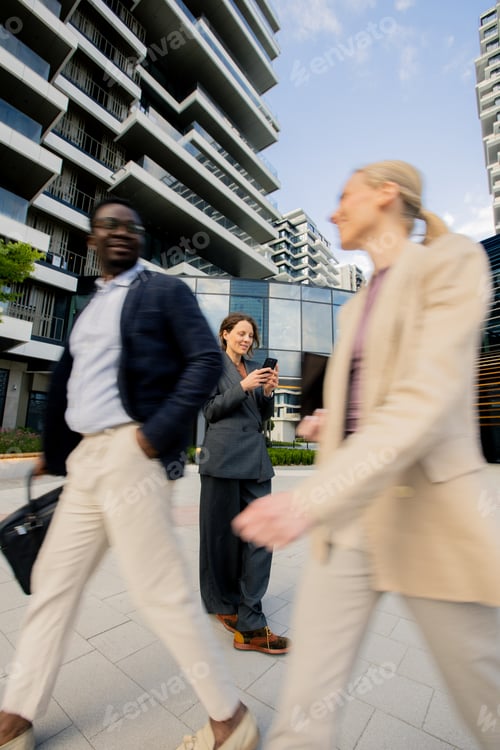 Preview: People walking in a modern city area with buildings in the background during daytime