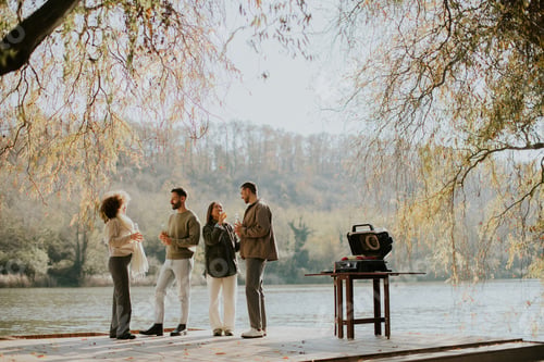 Preview: Gathering by the river in autumn with friends enjoying a cozy afternoon together