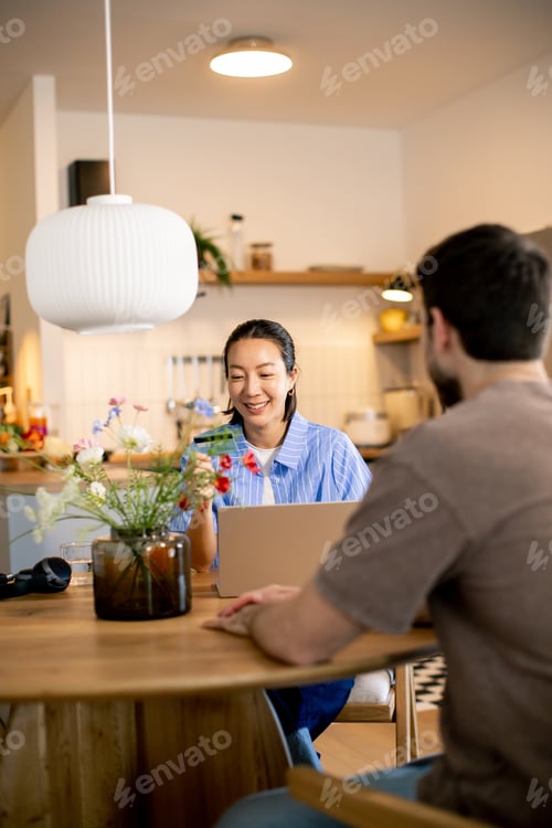 Preview: Couple enjoying conversation over coffee in a modern kitchen at midday