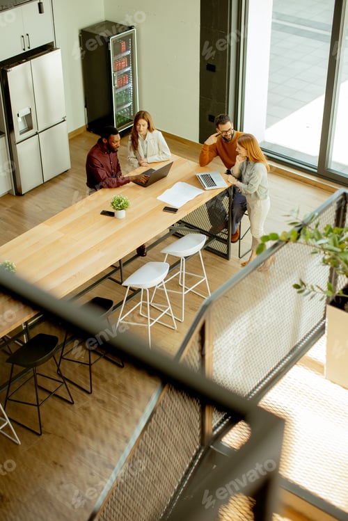 Aperçu: Group of people working together at a table in a bright office during the day