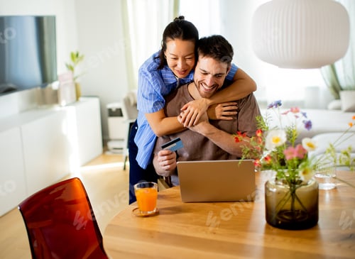 Preview: Couple enjoys online shopping together at home while sharing a joyful moment