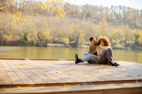 Preview: Couple enjoying a sunny afternoon by the lake during autumn foliage
