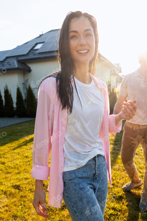 Preview: Young woman enjoying summer water fun in garden