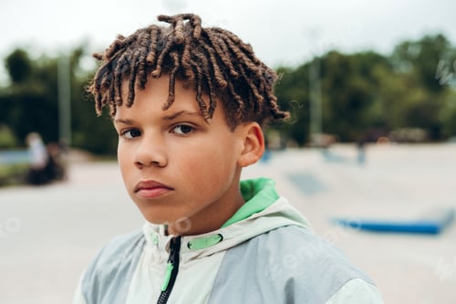 Preview: Portrait of teenage boy with dreadlocks portrait at skatepark, posing at camera