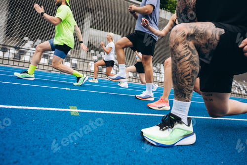 Preview: Group of athletes doing lunges on running track