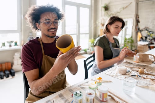 Preview: Man and woman painting pottery in art studio