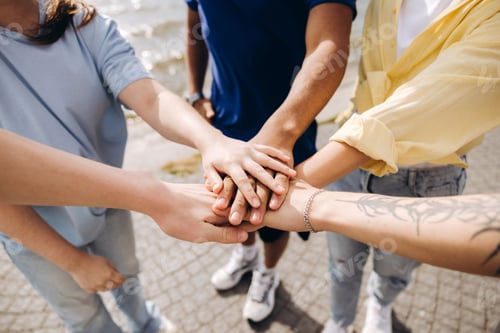 Preview: Group of diverse teenagers stacking hands for unity