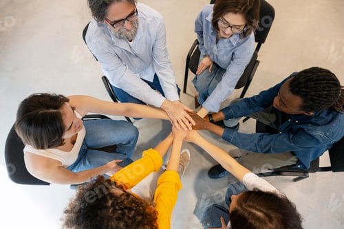 Preview: Diverse people stacking hands showing teamwork and unity