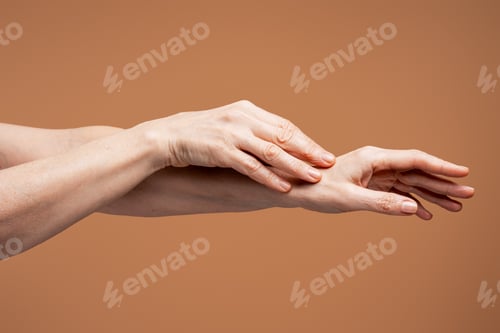 Preview: Woman applying skincare cream on aging hands