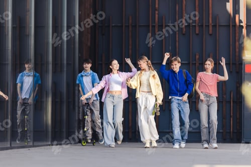 Preview: Diverse group of teen boys and girls walking together waving hands, on the street in urban city