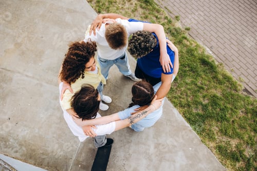 Preview: Diverse teenagers forming unity circle at skatepark