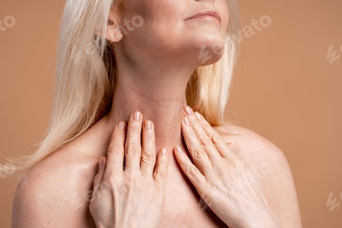 Preview: Senior woman touching neck checking skin for wrinkles
