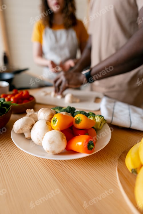 Preview: Diverse couple preparing healthy meal with fresh vegetables