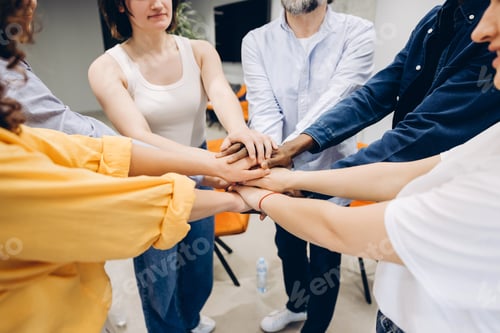 Preview: Diverse people stacking hands showing teamwork and cooperation selective focus on hands