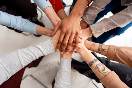 Preview: Diverse group stacking hands for teamwork and unity