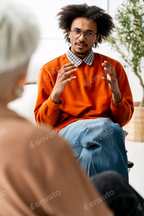 Preview: Young black man counseling older person during therapy session