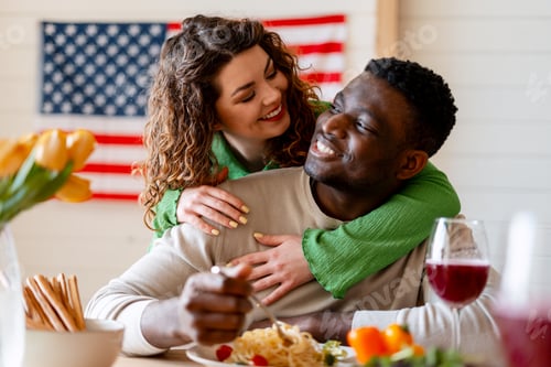 Preview: Young multicultural couple enjoying dinner with smiles