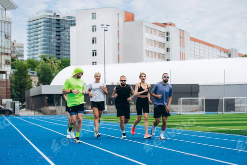 Preview: Group of diverse runners training on blue athletics track