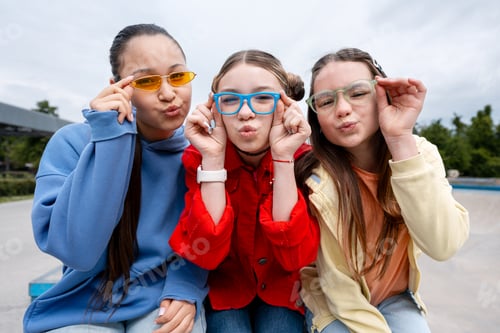 Preview: Teen girls making funny faces wearing colorful glasses