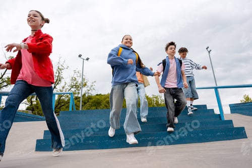 Preview: Teenagers running down stairs at skatepark together