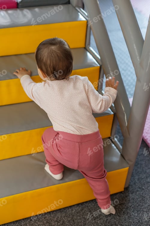 Preview: Toddler climbing stairs at indoor soft play playground