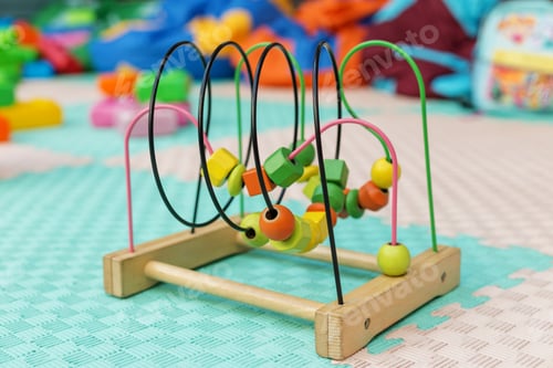 Preview: Colorful wooden bead maze toy on playroom floor