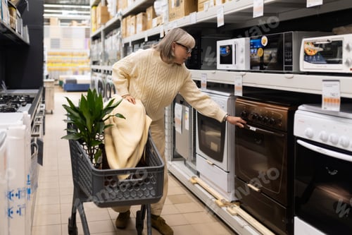 Preview: Woman shopping for a new oven in the home appliance department