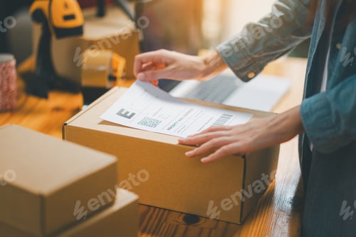 Preview: Startup Young Female Small Business Owners Attaching Shipping Labels to Cardboard Boxes or Parcels F