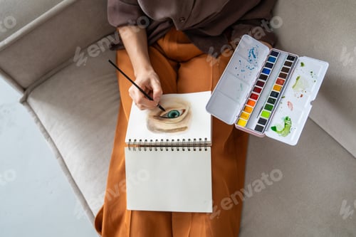 Preview: Person Painting a Realistic Eye With Watercolors in a Sketchbook