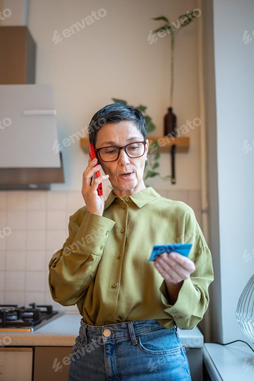Preview: Concerned elder woman talking on smartphone with financial scammers, sharing personal data to thefts