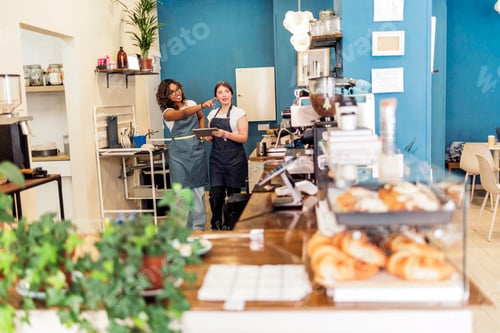 Preview: Baristas collaborating and discussing work in modern cafe