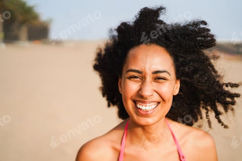 Preview: Happy young african woman having fun on the beach during summer vacation