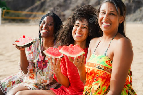 Preview: Multiracial girls eating watermelon while doing picnic on the beach