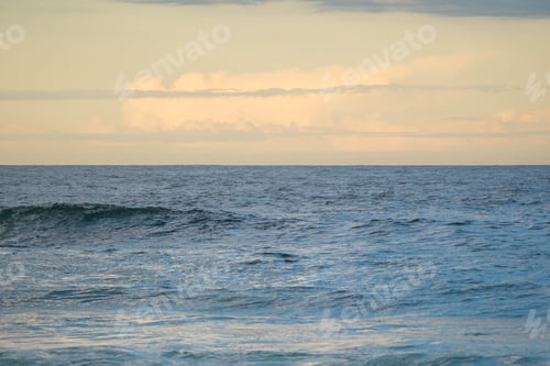 Preview: Dramatic breaking waves beneath a glowing sunset sky
