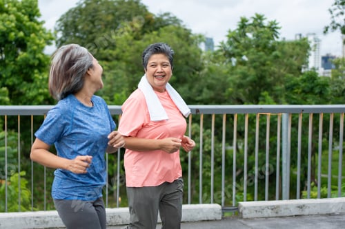 Preview: Two happy Asian senior women jogging exercise outdoors in modern city.