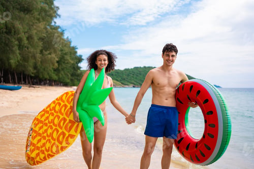 Preview: Portrait of Caucasian man and Latino woman stand on sandy beach together.
