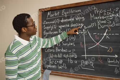 Preview: Black Young Adult Man Teaching Market Equilibrium on Classroom Chalkboard