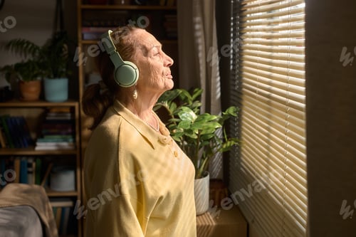 Preview: Senior Woman Wearing Headphones Relaxing at Home for Wellbeing