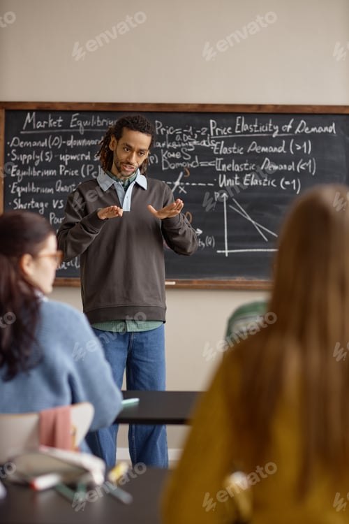 Preview: Vertical of Black Male Teacher Explaining Economics Lesson in Classroom