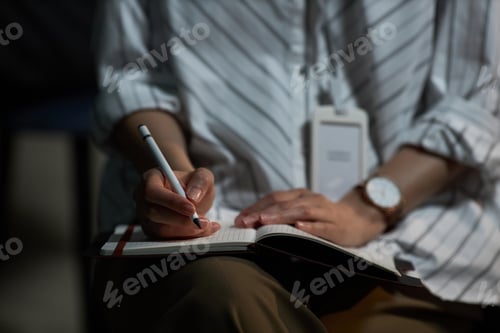 Preview: Adult Woman Writing Notes in Notebook for Business Planning