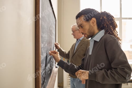 Preview: Black Adult Man Solving Equations in Classroom with Senior Teacher