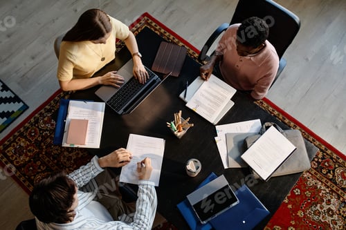 Preview: Diverse Adult Colleagues Reviewing Documents in Team Meeting