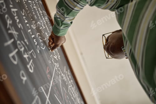 Preview: Black Teenage Boy Writing Math Equations on Blackboard in Classroom