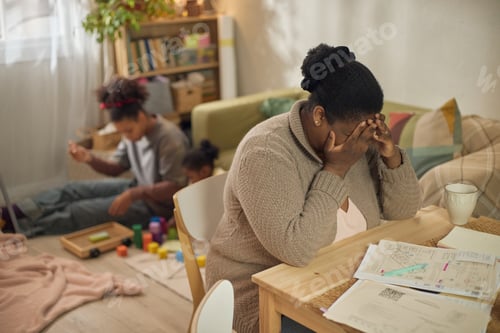 Preview: Black Mother Covering Face While Struggling with Household Bills