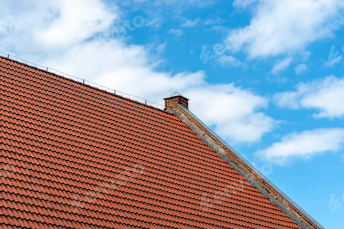 Preview: Traditional Orange Clay Tile Roof Against a Clear Blue Sky