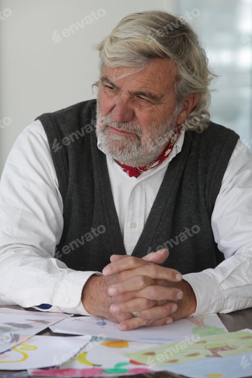 Preview: Sad Senior Man at Home With Child Drawings