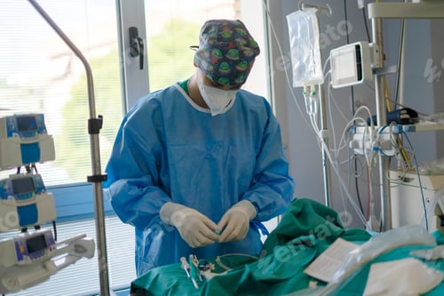 Preview: Medical professional preparing for surgery in operating room