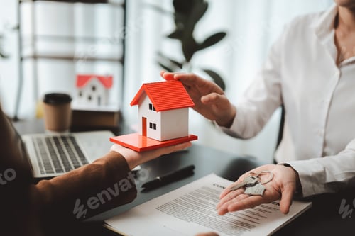 Preview: Real estate agent handing over house model and keys to client, symbolizing home ownership, property