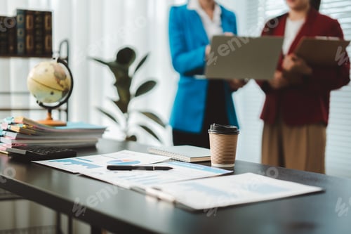 Preview: Business professionals analyzing data and preparing new strategies in a modern office, focusing on f